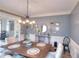 Dining room featuring a wooden table, decorative chandelier, and adjacent playroom to keep the close at 3145 Sweet Basil Ln, Loganville, GA 30052