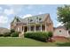 Beautiful two-story home with a classic brick facade, covered porch, and lush green lawn at 3145 Sweet Basil Ln, Loganville, GA 30052