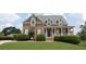Charming brick two-story home with a welcoming front porch and well-manicured landscaping at 3145 Sweet Basil Ln, Loganville, GA 30052