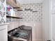 Modern laundry room with gray floral wallpaper, floating shelves, and front load machines at 3145 Sweet Basil Ln, Loganville, GA 30052