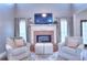 Cozy living room featuring a brick fireplace, comfortable armchairs, and elegant decor at 3145 Sweet Basil Ln, Loganville, GA 30052
