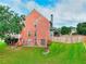 Two story home featuring brick and neutral siding, a wood fence, a back patio, and a well-maintained lawn at 3145 Sweet Basil Ln, Loganville, GA 30052