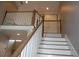 Bright staircase featuring white risers and wood treads leading to a second-story landing with white railing at 3145 Sweet Basil Ln, Loganville, GA 30052