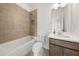 Bright bathroom featuring modern vanity and a tiled tub and shower at 382 Tillman Pass, Woodstock, GA 30188