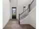 Bright and airy entryway with hardwood floors, staircase, and a black-framed glass front door at 382 Tillman Pass, Woodstock, GA 30188