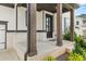 Inviting front porch with brick accents, wooden columns, and a stylish black front door at 382 Tillman Pass, Woodstock, GA 30188