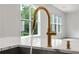 Close up of a modern gold kitchen faucet with pull-down sprayer and sleek design at 382 Tillman Pass, Woodstock, GA 30188