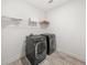 Convenient laundry room with modern washer and dryer and shelving at 382 Tillman Pass, Woodstock, GA 30188