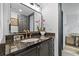 Bathroom with dark cabinetry, granite countertop, gold fixtures, and a plant for decoration at 4248 River Green Dr # 305, Atlanta, GA 30327