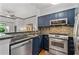Stylish kitchen boasts dark blue cabinets, granite countertops, stainless steel appliances, and a tiled backsplash at 4248 River Green Dr # 305, Atlanta, GA 30327