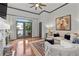 Bright living room features hardwood floors, a plush sofa, a ceiling fan, and access to a balcony at 4248 River Green Dr # 305, Atlanta, GA 30327