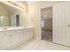 Bright bathroom with a double vanity, tile flooring, and access to the main bedroom at 5821 Saint Miles Drive Dr, Buford, GA 30518