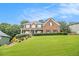 Charming brick home featuring a well-maintained lawn and manicured hedges beneath a clear blue sky at 5821 Saint Miles Drive Dr, Buford, GA 30518