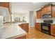 Cozy kitchen with wooden cabinets, granite countertops, black appliances, and a view of the breakfast nook at 5821 Saint Miles Drive Dr, Buford, GA 30518