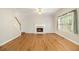 Open living room with hardwood floors, a fireplace, and abundant natural light at 5821 Saint Miles Drive Dr, Buford, GA 30518
