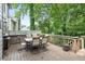 Back deck with a dining table and seating with lush greenery in the background at 2220 Cape Courage Way, Suwanee, GA 30024