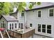 View of the back of the house with a wooden deck and outdoor dining area at 2220 Cape Courage Way, Suwanee, GA 30024