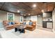 A finished basement features a wet bar with modern appliances, comfortable seating and natural light from windows at 2220 Cape Courage Way, Suwanee, GA 30024