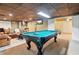 Finished basement with a pool table, comfortable seating area, wet bar, and finished ceiling at 2220 Cape Courage Way, Suwanee, GA 30024