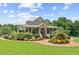 Clubhouse exterior with stone accents, covered porch, green lawn, and colorful landscaping at 2220 Cape Courage Way, Suwanee, GA 30024