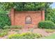 Richland community entrance with brick wall, mature trees, colorful flowers, and manicured landscaping at 2220 Cape Courage Way, Suwanee, GA 30024