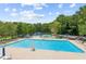 Large community pool with lounge chairs, umbrellas, and mature trees in a desirable neighborhood at 2220 Cape Courage Way, Suwanee, GA 30024