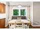 Cozy dining area features a large window overlooking lush greenery and table with seating at 2220 Cape Courage Way, Suwanee, GA 30024