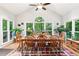 Light-filled dining room surrounded by large windows with views of the wooded landscape at 2220 Cape Courage Way, Suwanee, GA 30024