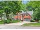 Two-story brick home featuring a manicured lawn, mature landscaping, and attached two-car garage at 2220 Cape Courage Way, Suwanee, GA 30024