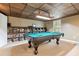 Spacious game room with pool table, custom wood ceiling, and built-in shelving for ample storage at 2220 Cape Courage Way, Suwanee, GA 30024