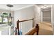 Open hallway and foyer with decorative hanging light, hardwood stairs, and natural light through large window at 2220 Cape Courage Way, Suwanee, GA 30024
