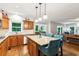 Well-lit kitchen featuring granite counters, wooden cabinets, and island seating with pendant lighting at 2220 Cape Courage Way, Suwanee, GA 30024