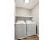Efficient laundry room featuring a side-by-side washer and dryer set with a floating shelf above at 2220 Cape Courage Way, Suwanee, GA 30024