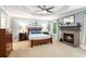 Serene main bedroom features a fireplace, tray ceiling with fan, and plush carpet flooring at 2220 Cape Courage Way, Suwanee, GA 30024