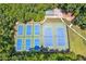 Aerial view of well-maintained tennis courts surrounded by mature trees for a private feel at 2220 Cape Courage Way, Suwanee, GA 30024