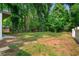 View of the backyard, with mature trees and a storage shed at 276 Lydia Se Dr, Atlanta, GA 30315