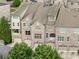 View of brick townhomes featuring attached garages and private balconies, surrounded by green landscaping at 4853 Stonehall Pl, Atlanta, GA 30339