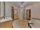 Large bathroom featuring dual sinks, a soaking tub, shower, and elegant lighting at 4853 Stonehall Pl, Atlanta, GA 30339