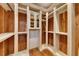 Walk-in closet with custom shelving, wooden walls, and a built-in cabinet with mirrors at 4853 Stonehall Pl, Atlanta, GA 30339