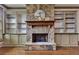 Close up of a stone fireplace with wooden mantel and built-in cabinets flanking either side at 4853 Stonehall Pl, Atlanta, GA 30339