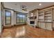 Bright living room featuring hardwood floors, a stone fireplace, custom built-ins, and recessed lighting at 4853 Stonehall Pl, Atlanta, GA 30339
