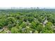 A distant aerial view of a house nestled among green trees in a neighborhood with a city skyline in the background at 1026 Reeder N Cir, Atlanta, GA 30306