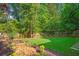 Well-maintained backyard featuring a lush lawn, wooden fence, and a rock bed with manicured plants at 1026 Reeder N Cir, Atlanta, GA 30306