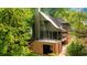 View of backyard showcasing brick structure, stairs, upper porch, and mature landscaping at 1026 Reeder N Cir, Atlanta, GA 30306