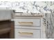 Close-up on kitchen drawers with gold hardware and marble countertops and backsplash at 1026 Reeder N Cir, Atlanta, GA 30306