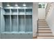 Custom mudroom with built-in cubbies, storage cabinets, and a staircase with modern metal railing at 1026 Reeder N Cir, Atlanta, GA 30306
