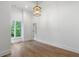 Expansive room with light hardwood floors, white walls and trim, and an elegant hanging light at 1026 Reeder N Cir, Atlanta, GA 30306