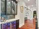 An elegant bar area features glass cabinets, a wine fridge, marble countertops, and beautiful blue backsplash at 980 Fenimore Cir, Atlanta, GA 30350