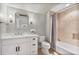 Bright bathroom features a white vanity with marble countertop and a tiled shower with tub at 980 Fenimore Cir, Atlanta, GA 30350