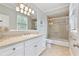 Bright bathroom features a tiled shower with glass doors and a vanity with ample storage at 980 Fenimore Cir, Atlanta, GA 30350